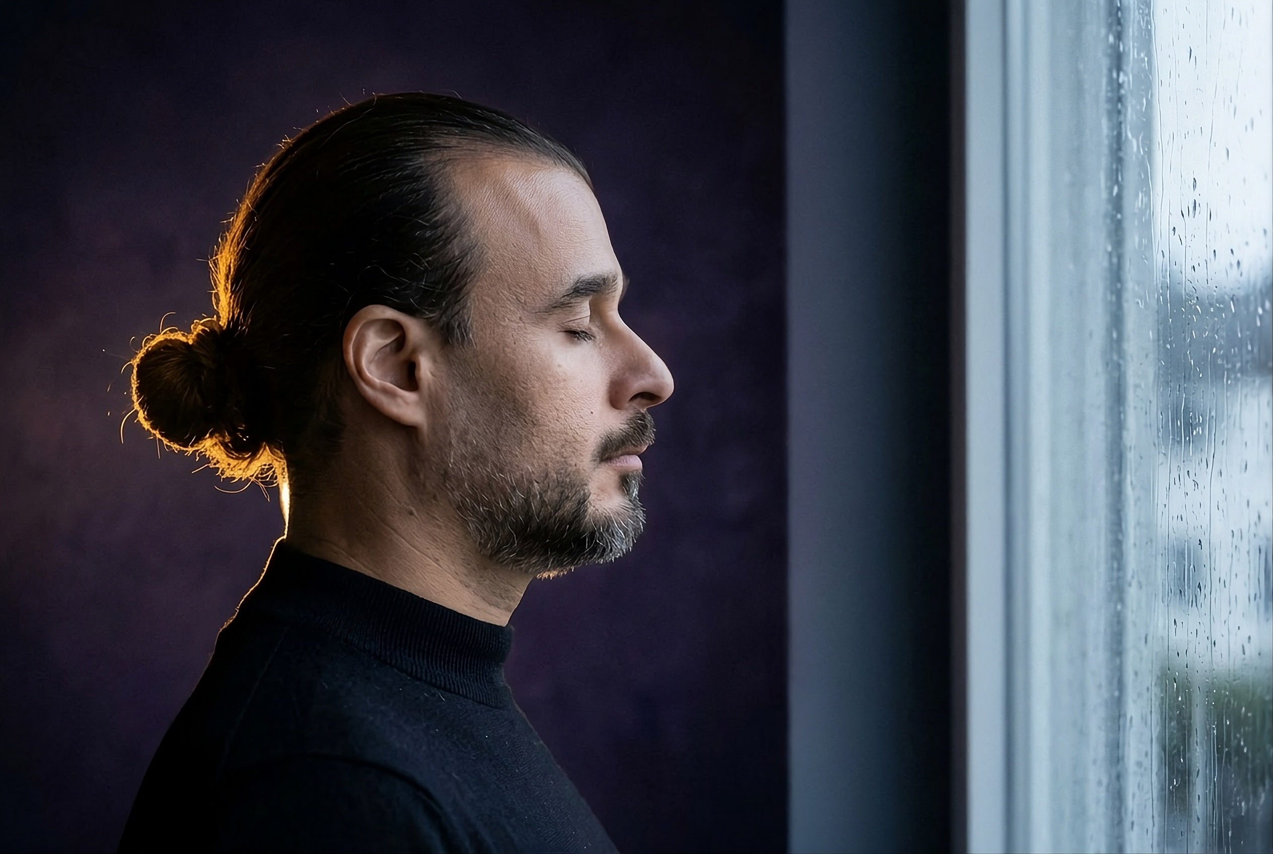 Hassan El Aashar, founder of FRAGORE, in profile beside a rain-streaked window